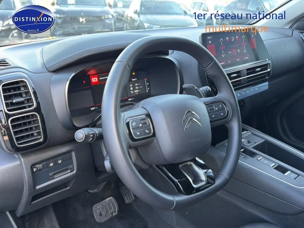 Vue intérieure du poste de conduite du Citroën C5 Aircross 2025, volant multifonction et écran tactile visibles.