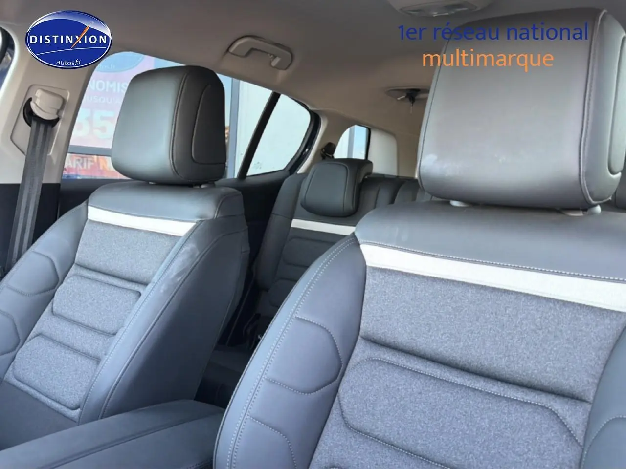 Vue intérieure des sièges avant et arrière du Citroën C5 Aircross 2025, avec sellerie gris clair et détails en cuir noir.