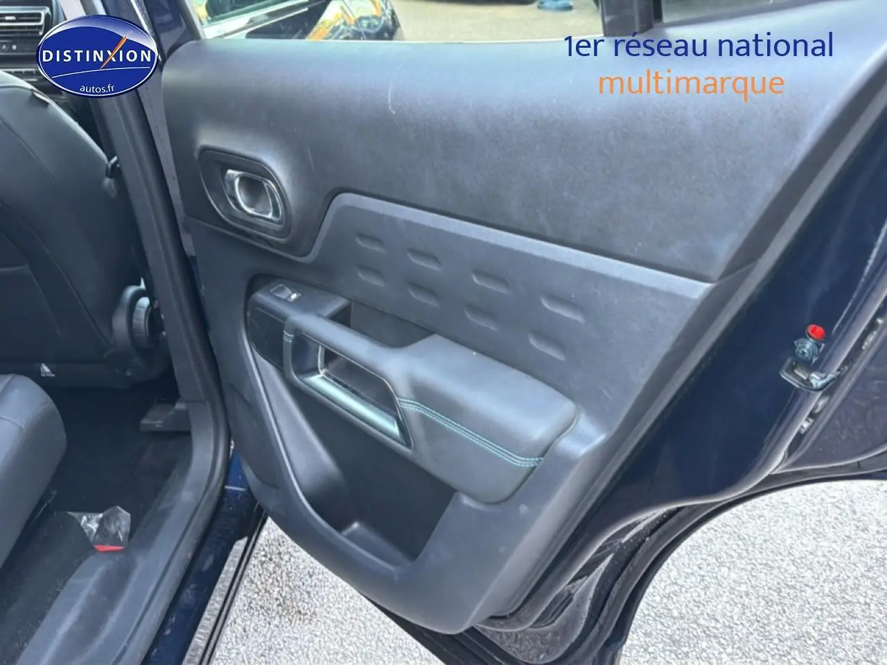 Vue intérieure du côté gauche arrière de la porte bleu eclipse du Citroën C5 Aircross avec poignée et accoudoir noir.