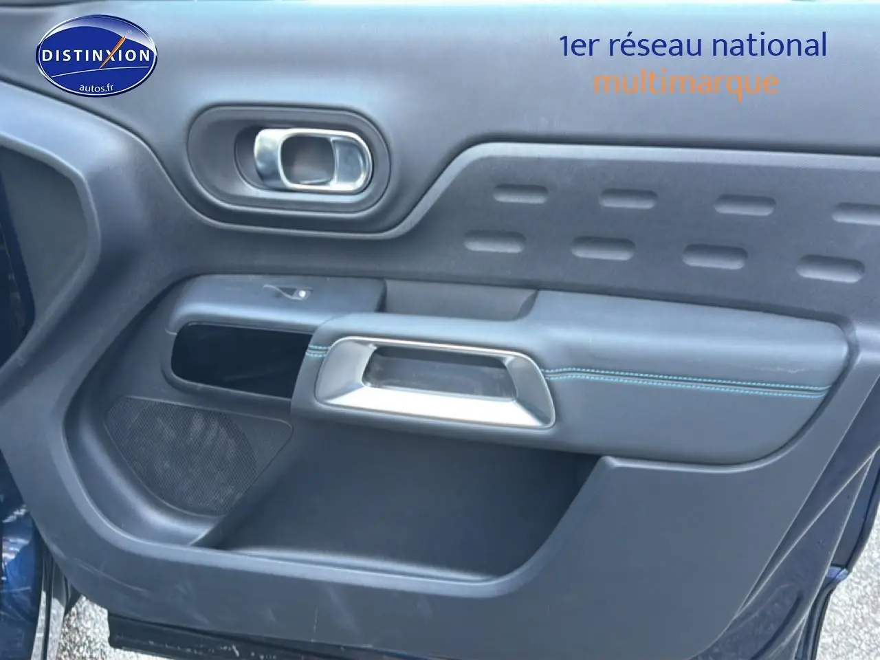 Gros plan sur la porte côté gauche du Citroën C5 Aircross bleu eclipse avec poignée argent et surpiqûres bleues.