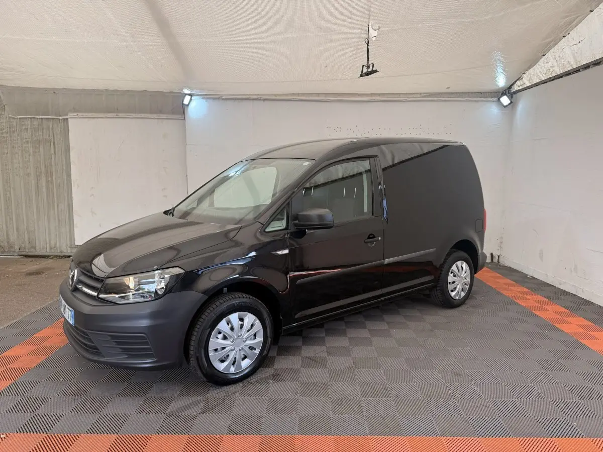Vue 3/4 avant droite d'un Volkswagen Caddy noir 2019 utilitaire avec jantes acier et pare-chocs noirs mat.
