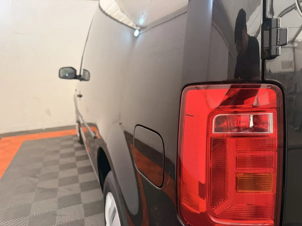 Vue arrière côté droit du Volkswagen Caddy noir 2019 avec feu arrière rouge et porte de réservoir visible.