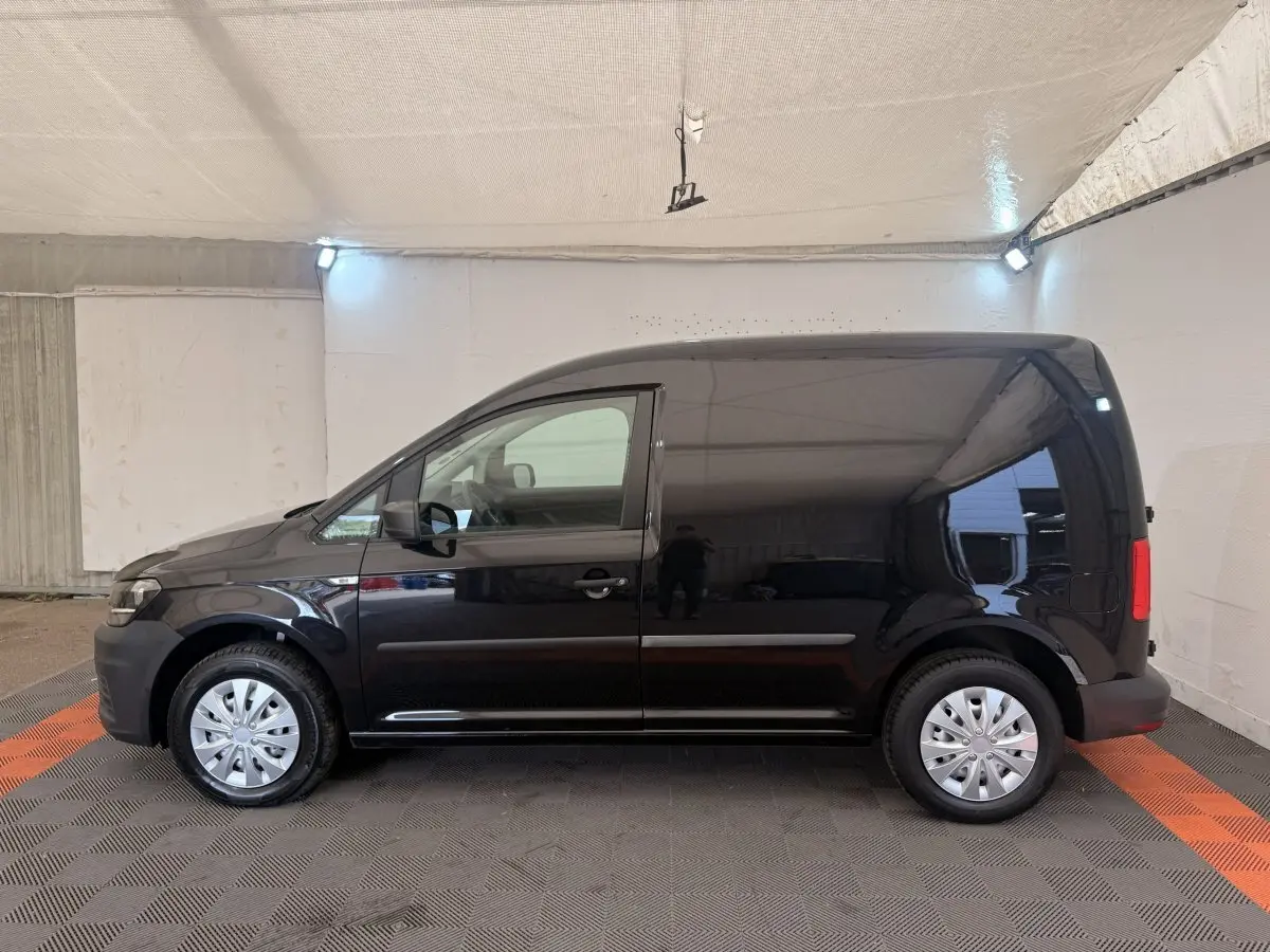 Vue latérale gauche d'un Volkswagen Caddy noir 2019, fourgon compact avec jantes acier et portes latérales lisses.