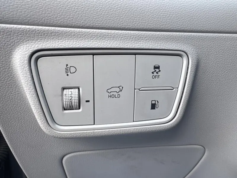 Panneau de commandes gris clair avec réglage des phares, maintien de frein, contrôle de stabilité et ouverture du réservoir sur Hyundai Tucson Teal Blue.