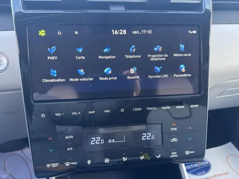 Écran tactile central du Hyundai Tucson 1.6 T-GDi PHEV 2021 en Teal Blue Métal, affichant menu multimédia et climatisation.