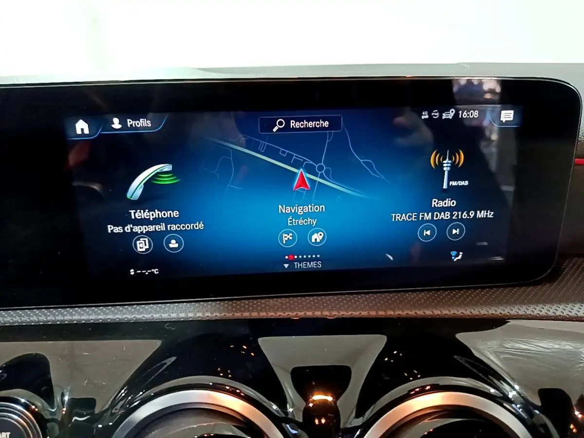 Écran tactile central du tableau de bord de la Mercedes Classe A 200 AMG Line noir, affichant navigation et radio.