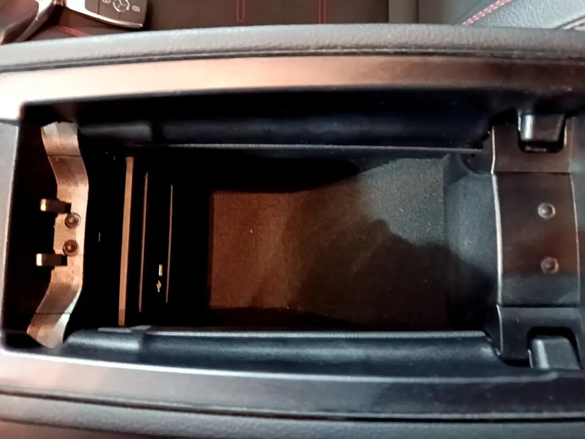 Vue plongeante sur le rangement central noir ouvert de la Mercedes Classe A 200 AMG Line 2021 avec clé visible.