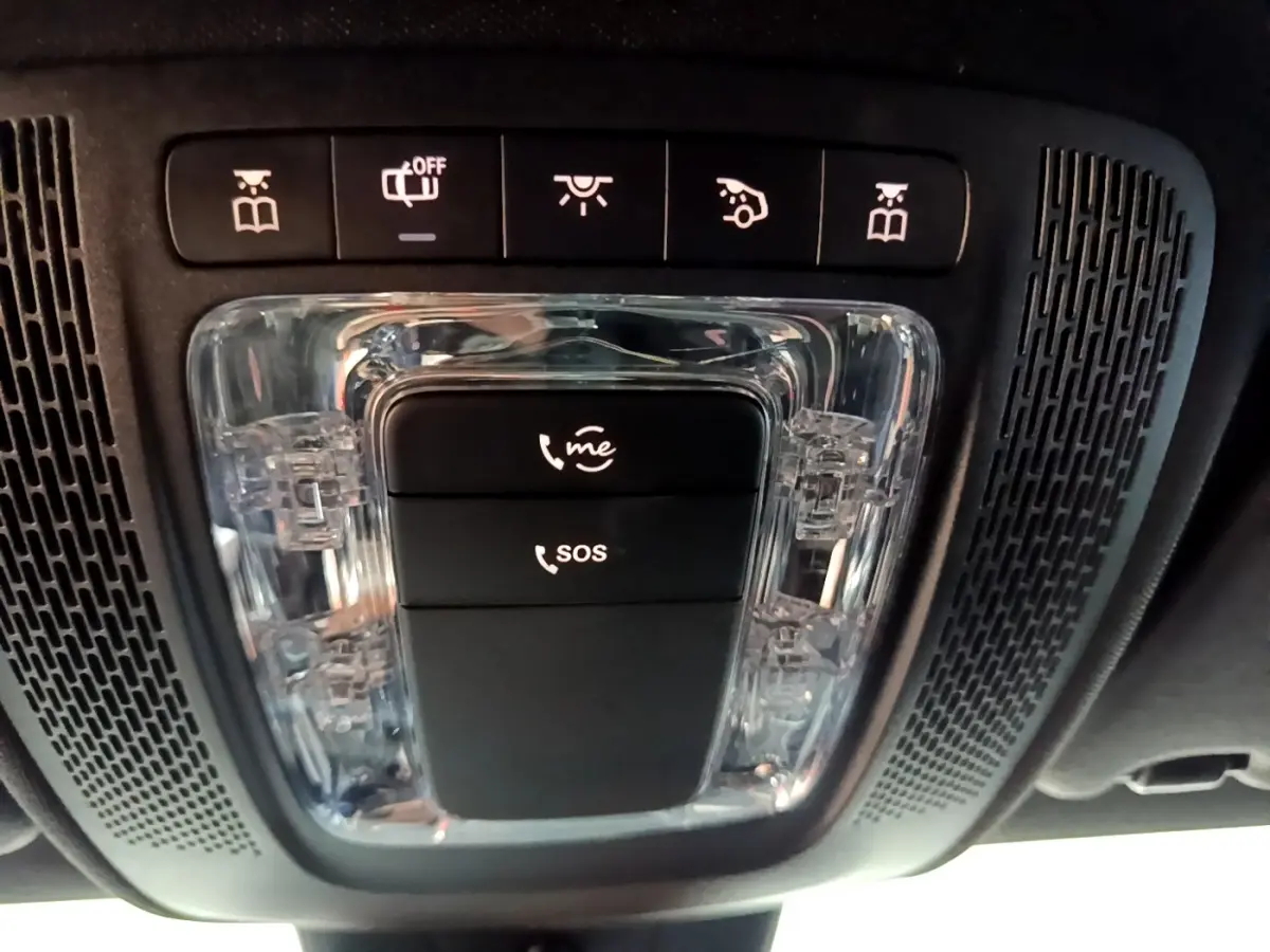 Gros plan sur la console de toit noire de la Mercedes Classe A 200 AMG Line avec boutons d’appel SOS et assistance.