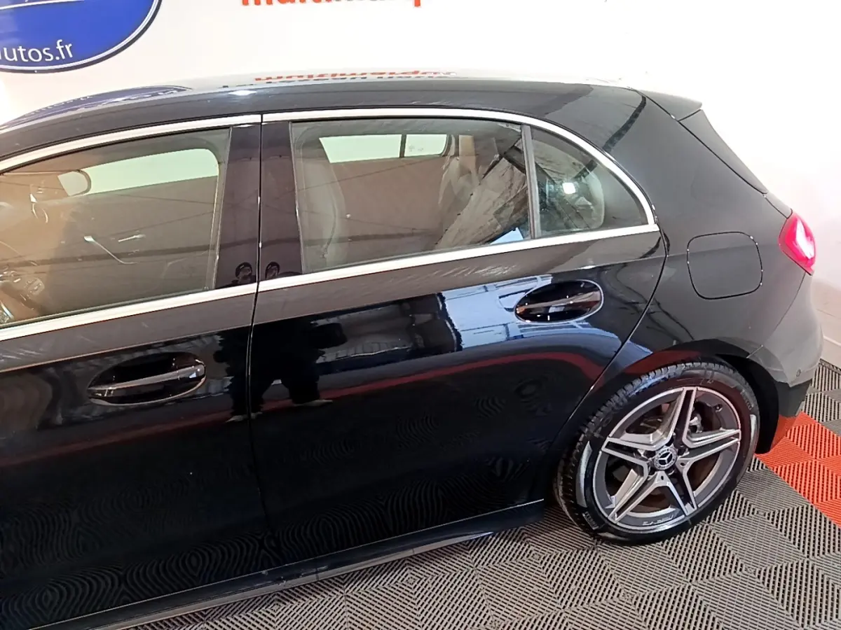Vue latérale droite d'une Mercedes Classe A A 200 AMG Line noire avec jantes alliage et poignées de porte chromées.