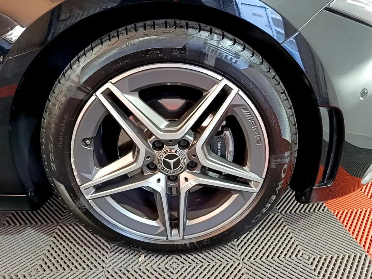 Gros plan sur la jante AMG argentée et le pneu Pirelli d’une Mercedes Classe A noire, côté arrière droit.