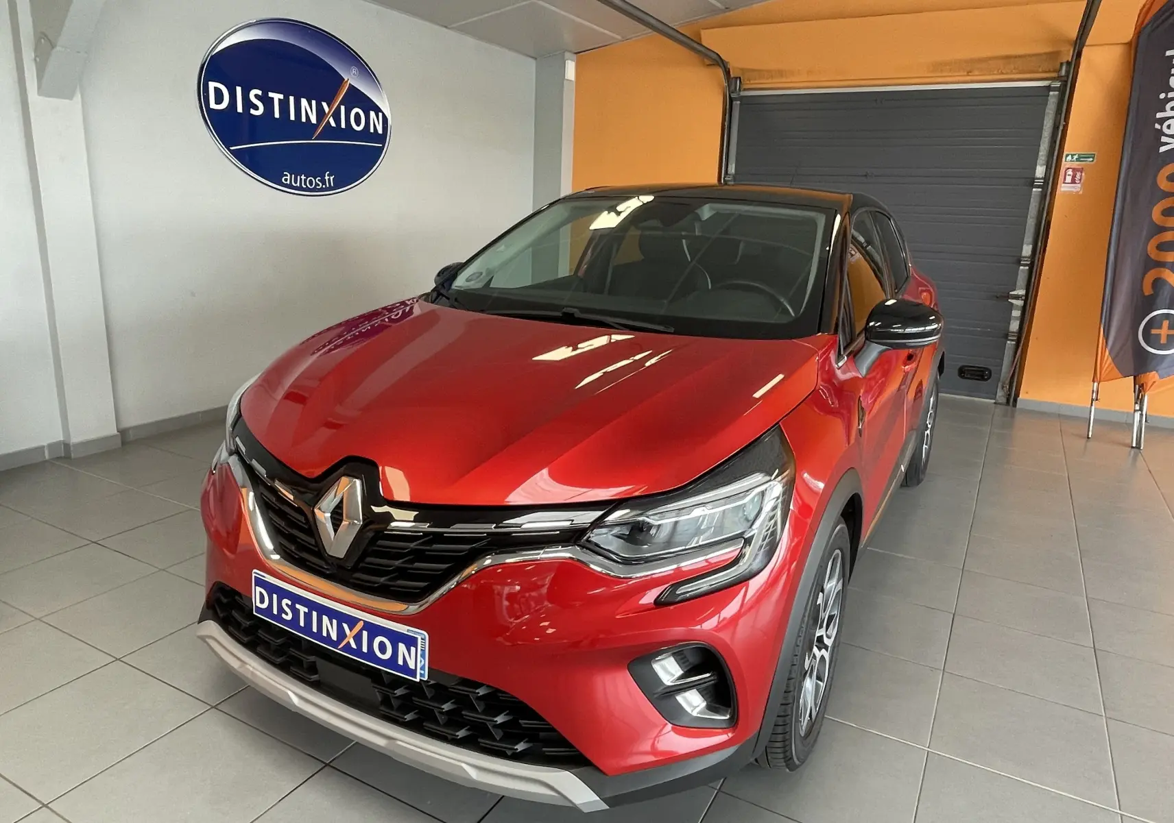 Renault Captur rouge en 3/4 avant droit, avec calandre noire brillante et jantes alliage distinctives.