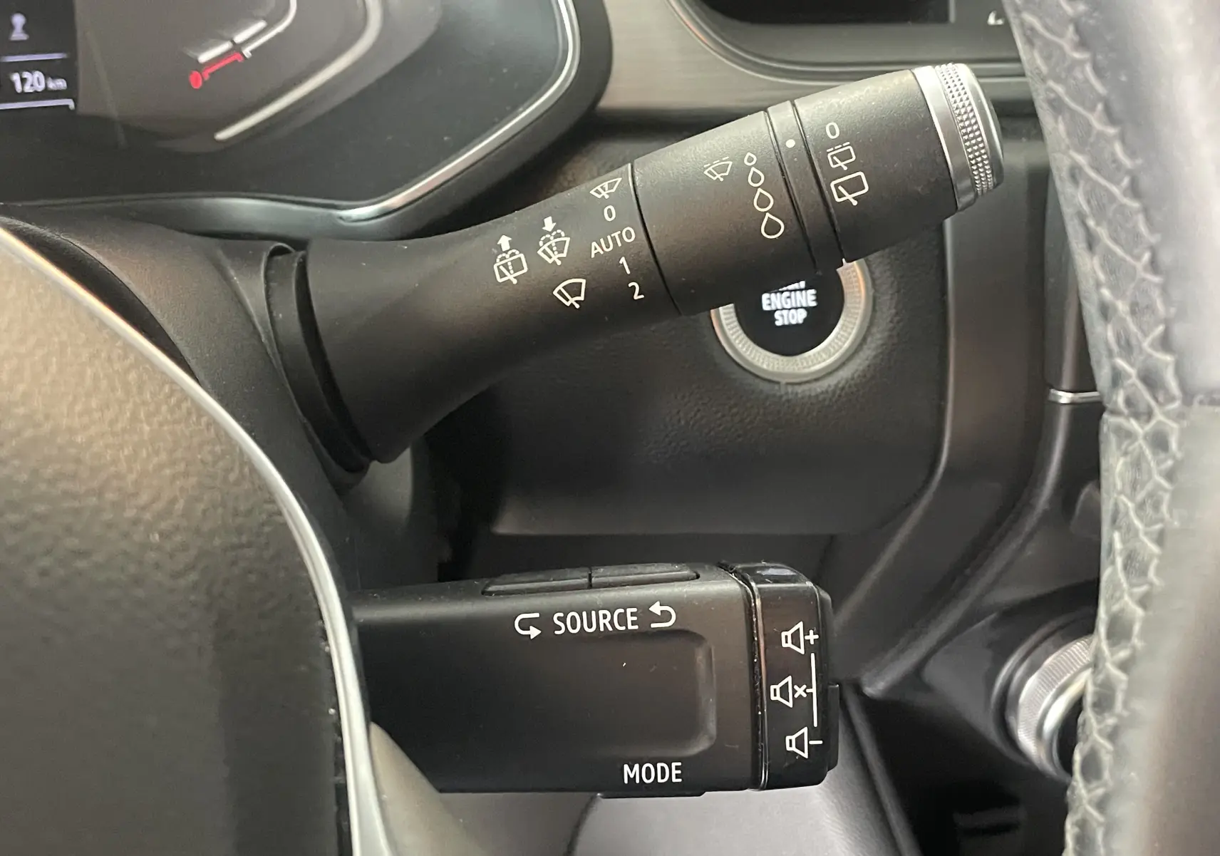 Gros plan sur les commandes au volant du Renault Captur rouge 2019, avec bouton start/stop visible en arrière-plan.