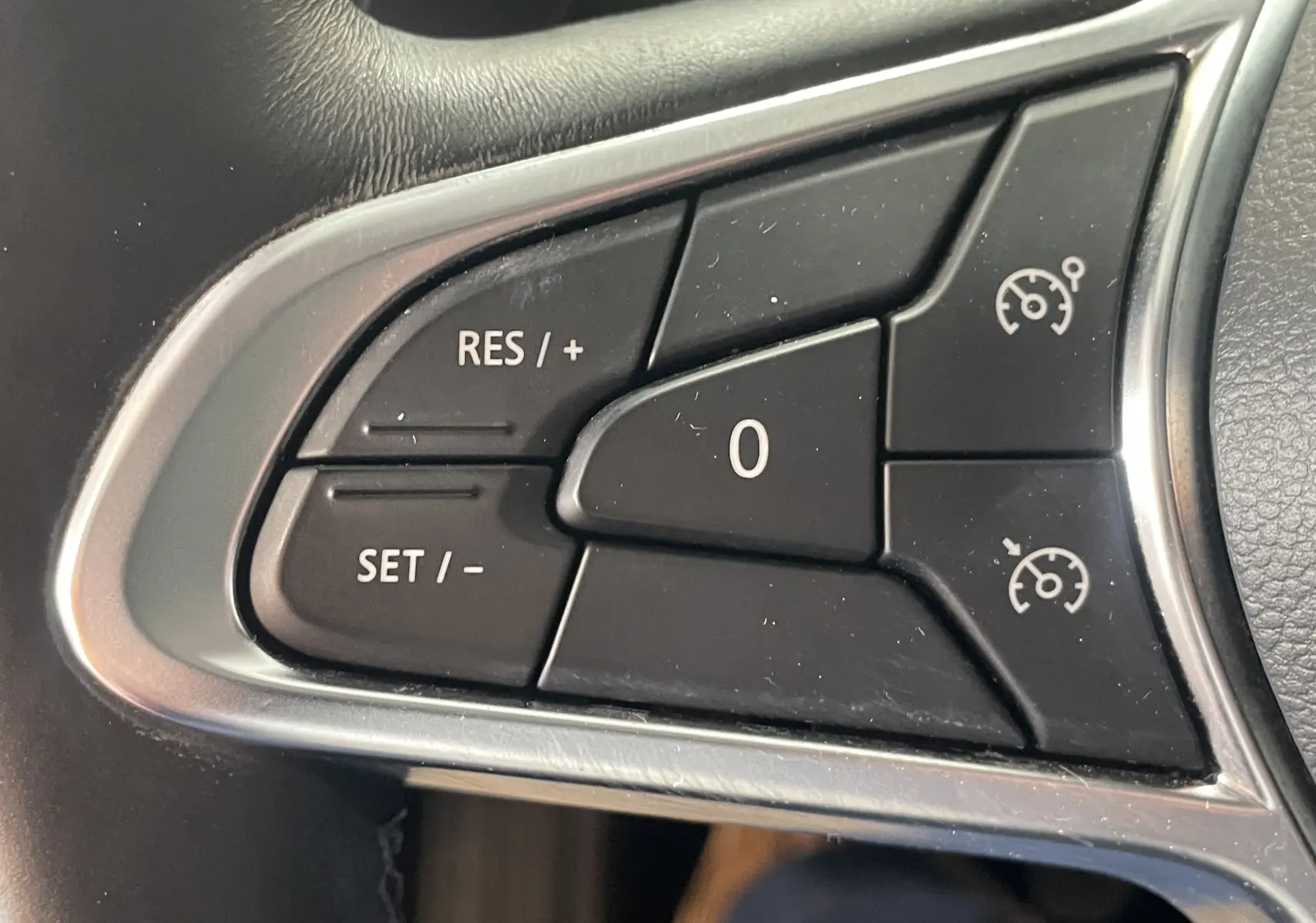 Gros plan sur les commandes de régulateur de vitesse au volant du Renault Captur rouge 2019, version Intens.