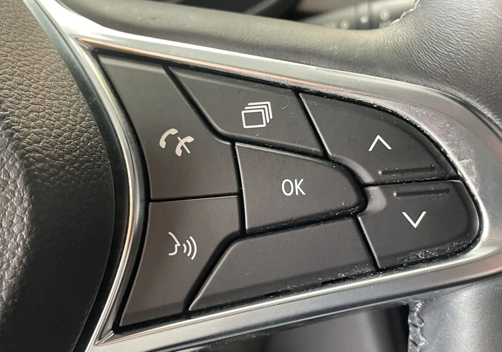 Gros plan sur les commandes noires du volant du Renault Captur 2019, avec boutons de navigation et appel.