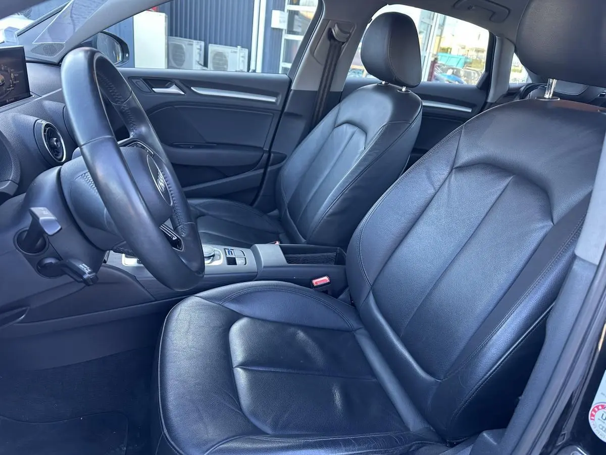 Vue intérieure côté conducteur de l'Audi A3 2020, sièges en cuir noir et volant multifonction trois branches.
