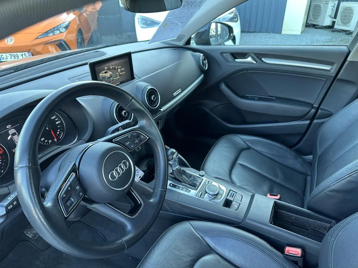 Vue intérieure côté conducteur de l'Audi A3 berline 2020 avec sellerie cuir noire et tableau de bord moderne.
