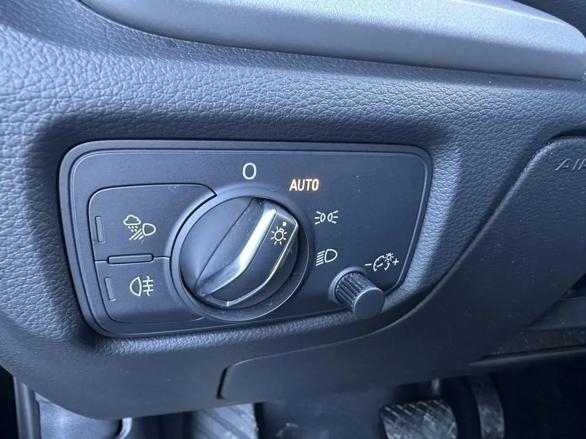 Gros plan sur le bouton de commande des phares de l'Audi A3 2020, intérieur noir avec réglage automatique des feux.