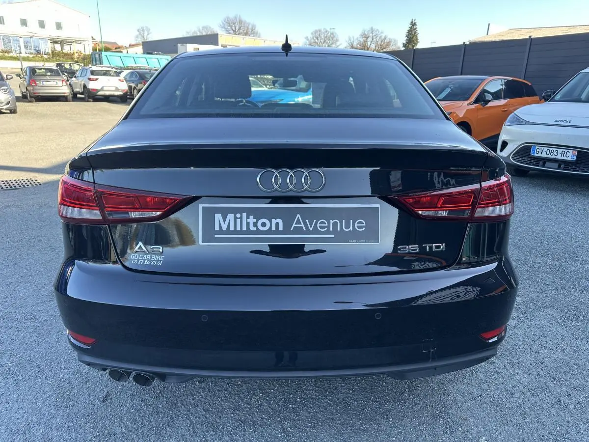 Vue arrière d'une Audi A3 berline noire 35 TDI avec feux rouges et double sortie d'échappement visible.
