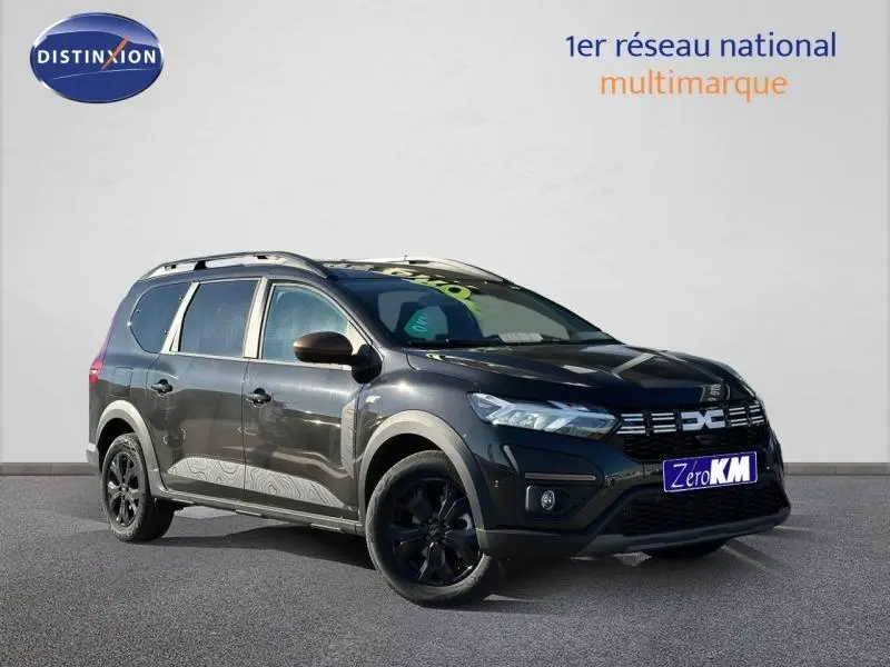 Dacia Jogger noir nacré métallisé en 3/4 avant droit avec barres de toit et jantes alu noires.