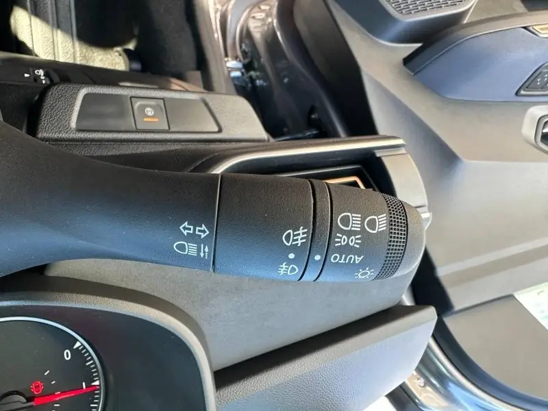 Gros plan sur la commande des phares et clignotants côté gauche dans l’habitacle noir nacré métallisé d’un Dacia Jogger 2024.
