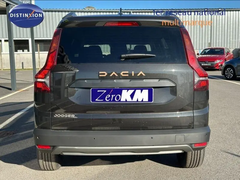 Vue arrière d'un Dacia Jogger noir nacré métallisé avec feux arrière en forme de L et logo DACIA visible.