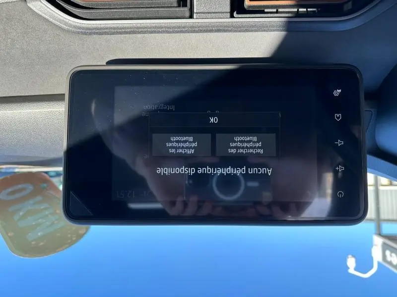 Écran tactile central du tableau de bord d’un Dacia Jogger 2024, affichant un message Bluetooth, intérieur noir.