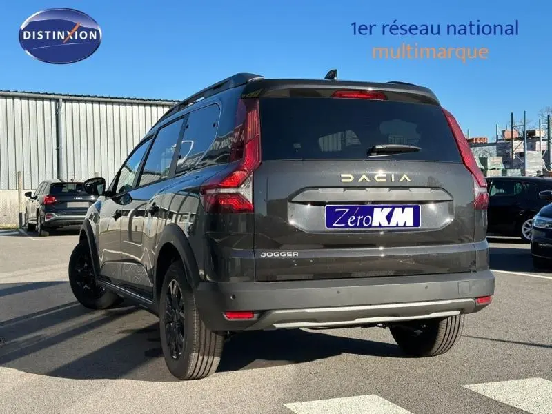 Vue 3/4 arrière droite d'un Dacia Jogger noir nacré métallisé avec barres de toit et jantes noires.