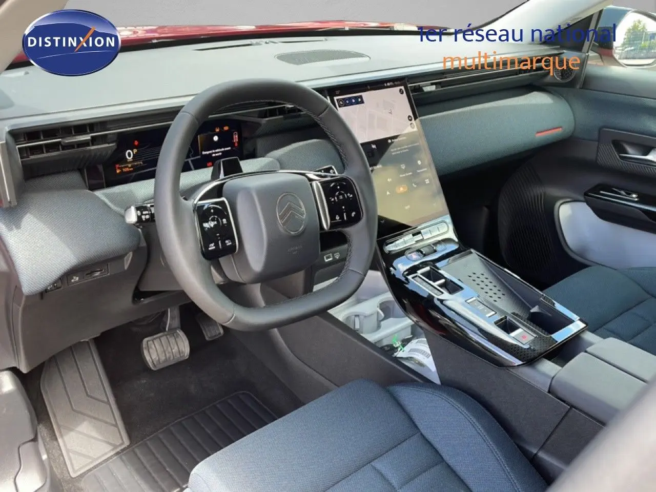 Vue intérieure du poste de conduite du Citroën C5 Aircross Hybrid rouge rubis, avec volant multifonction et écran tactile vertical.