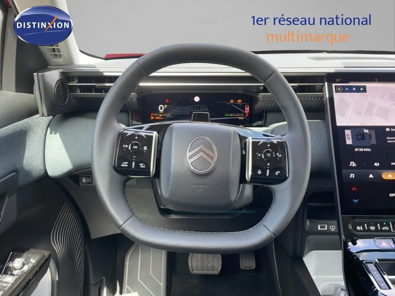 Vue centrée sur le volant cuir du Citroën C5 Aircross Hybrid rouge rubis, avec tableau de bord numérique et écran tactile visible.