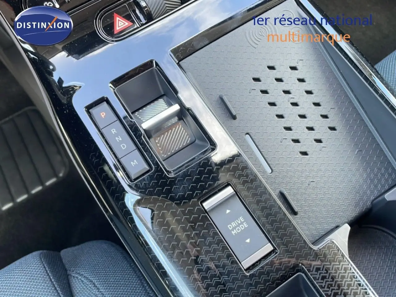 Gros plan sur la console centrale noire brillante du Citroën C5 Aircross Hybrid avec commandes de boîte auto et mode de conduite.