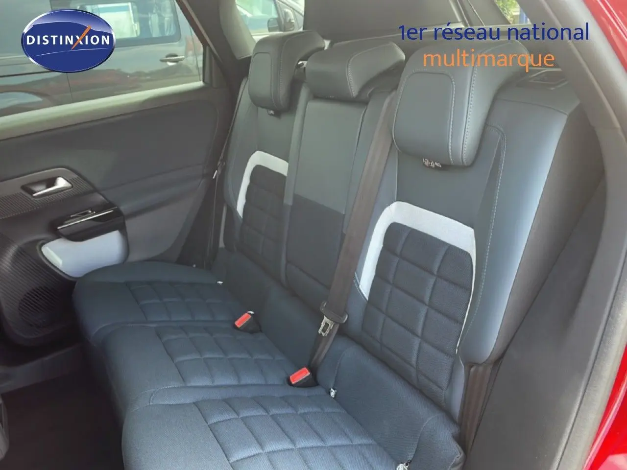 Vue intérieure du siège arrière côté droit du Citroën C5 Aircross rouge rubis, avec sellerie tissu et cuir noir à motifs carrés.