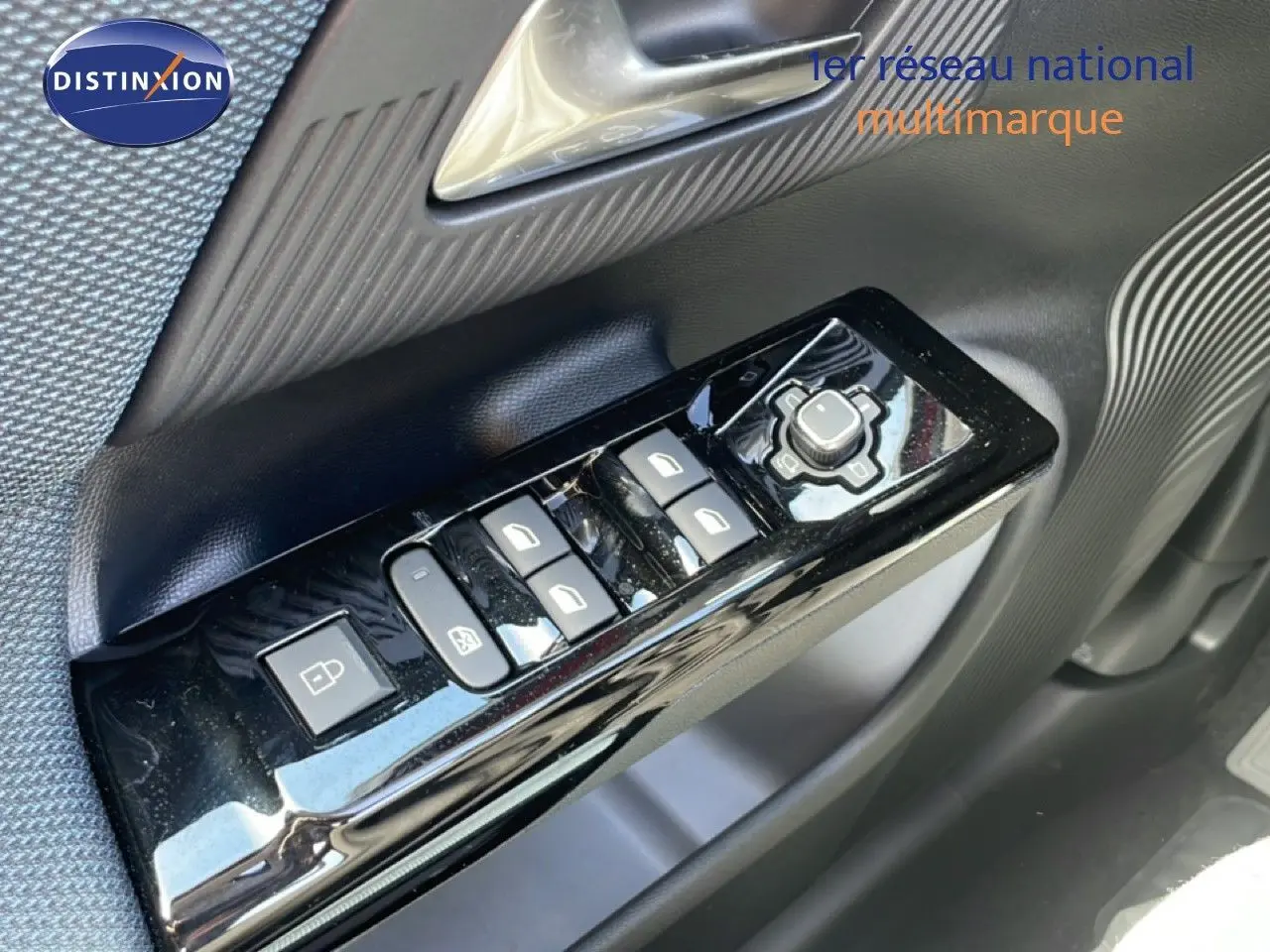Gros plan sur les commandes de lève-vitres et rétroviseurs côté conducteur du Citroën C5 Aircross Hybrid rouge rubis.