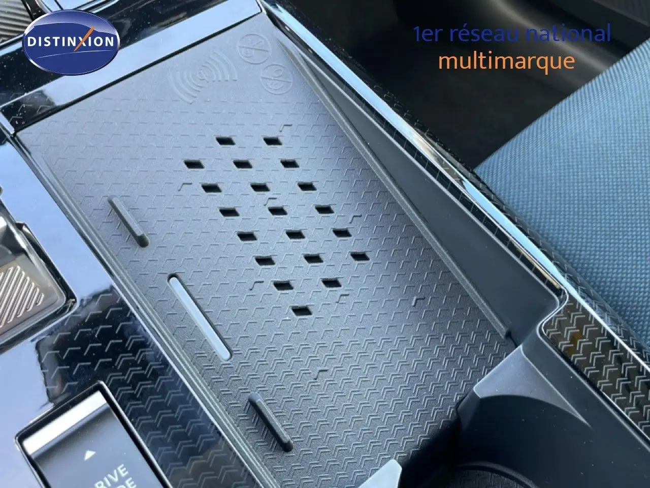 Gros plan sur la console centrale noire texturée du Citroën C5 Aircross Hybrid, avec partie siège tissu visible.