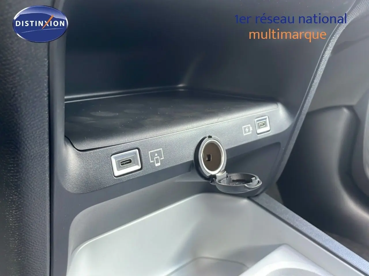 Prise USB-C et allume-cigare ouverts dans le rangement central d'un Citroën C5 Aircross Hybrid rouge rubis.