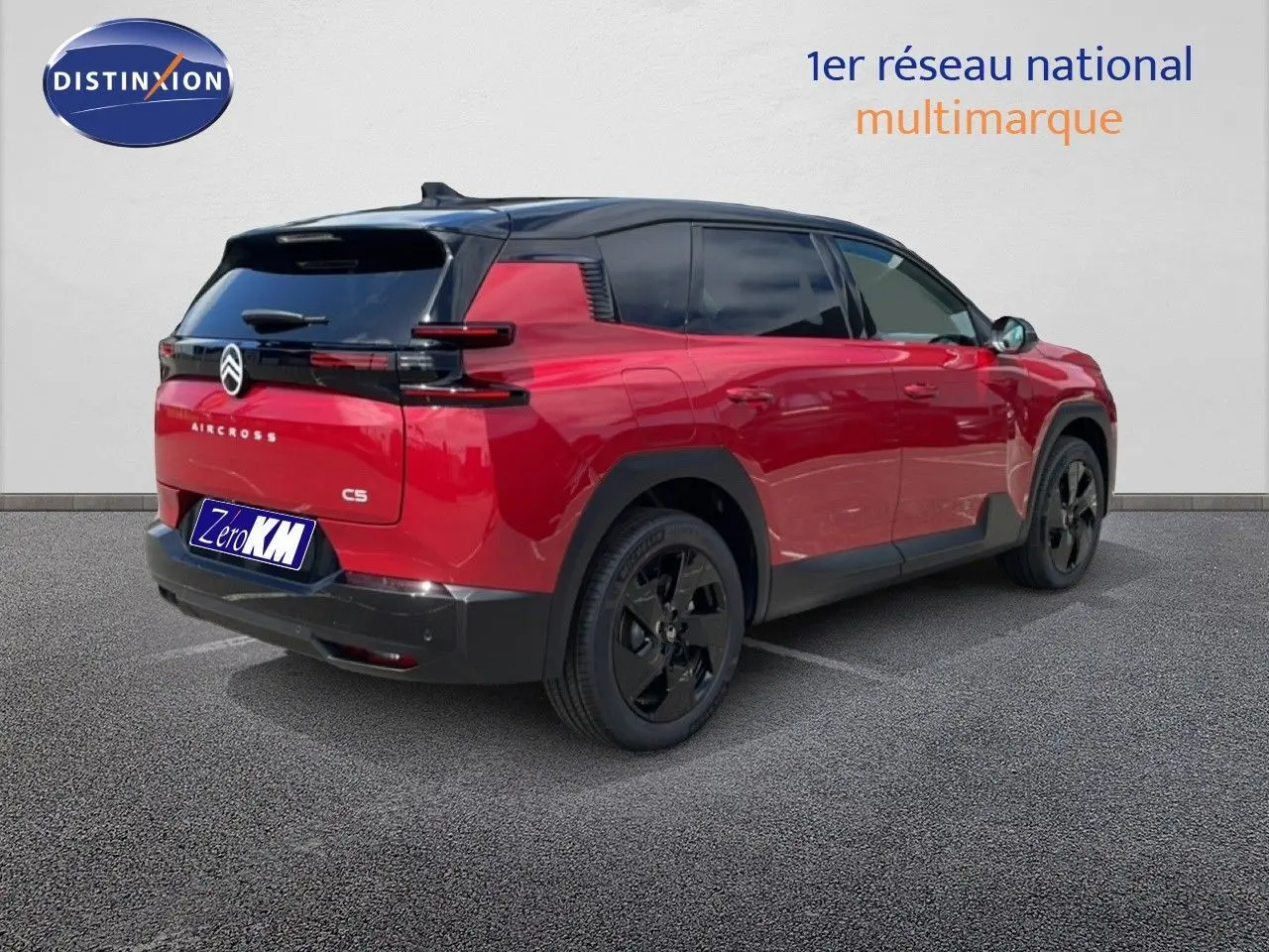 Vue 3/4 arrière droite d'un Citroën C5 Aircross Hybrid rouge rubis métallisé avec toit noir et jantes noires.