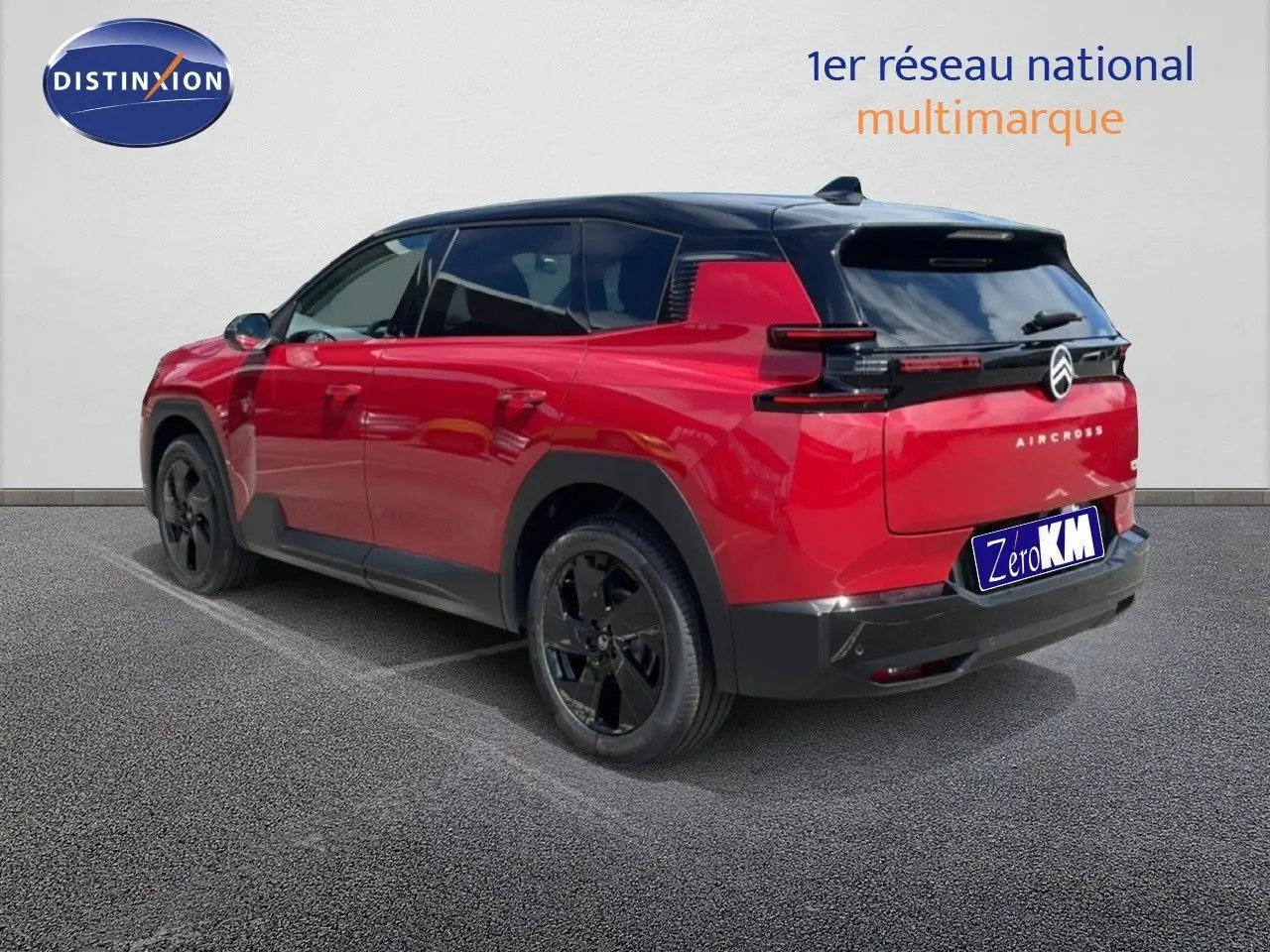 Vue 3/4 arrière droite d'un Citroën C5 Aircross rouge rubis métallisé avec toit noir et jantes noires.