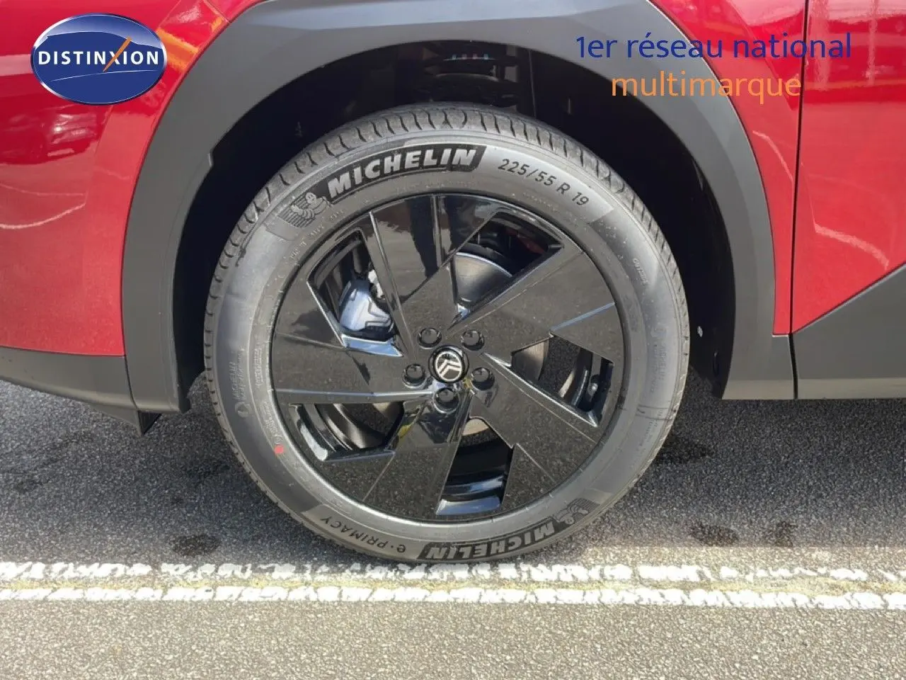 Gros plan sur la roue avant droite noire brillante du Citroën C5 Aircross Hybrid rouge rubis.
