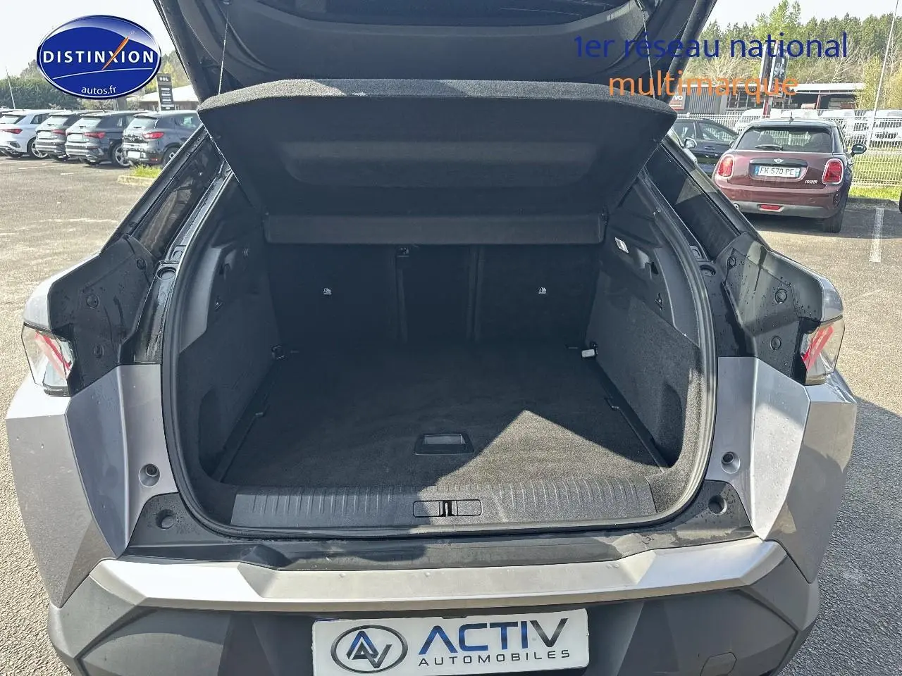 Coffre ouvert d’un Peugeot 3008 gris artense me vu de l’arrière, montrant un espace de chargement spacieux et propre.