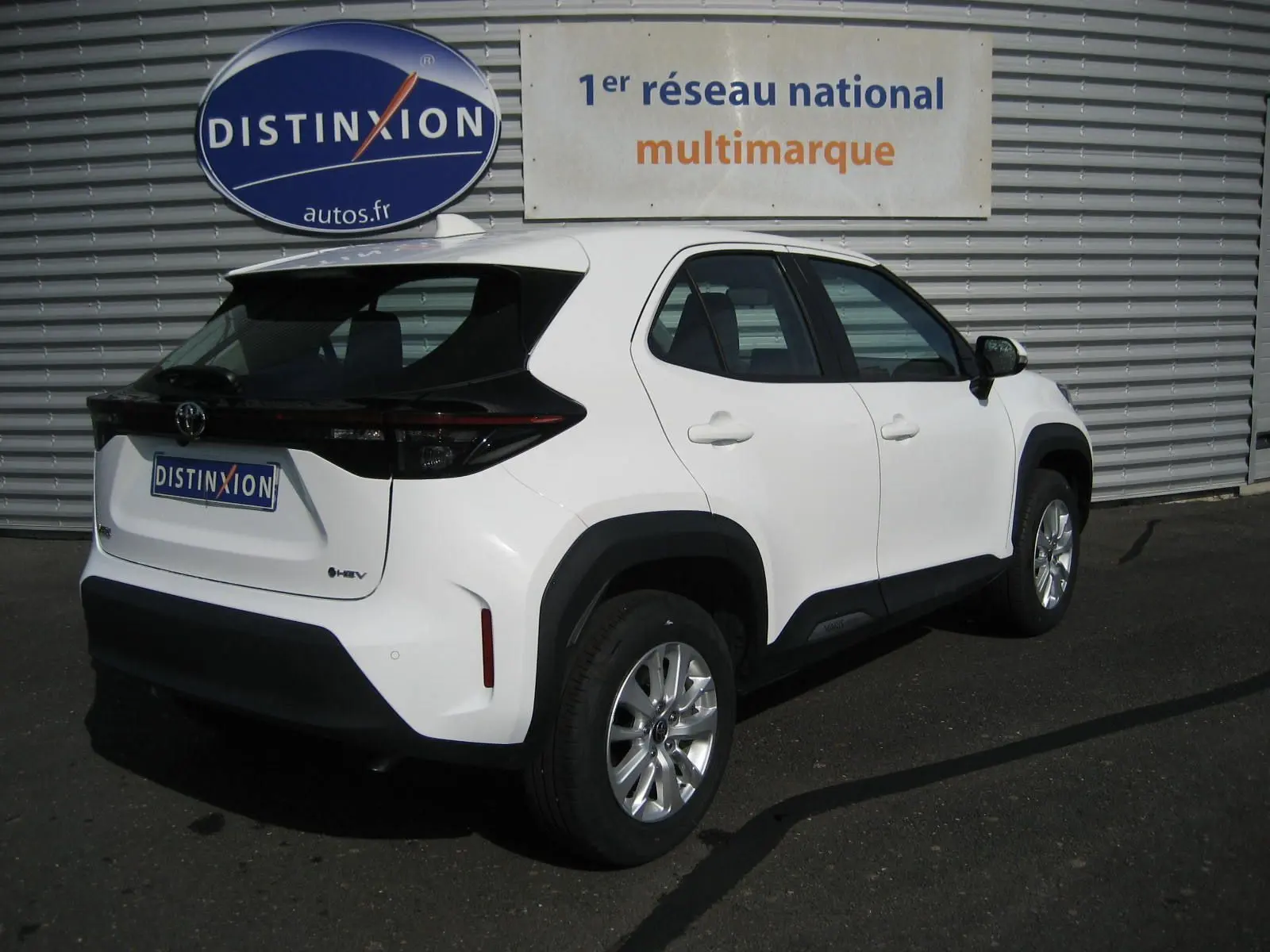 Toyota Yaris Cross blanc en vue 3/4 arrière droit, avec détails noirs contrastants et jantes alliage argentées.