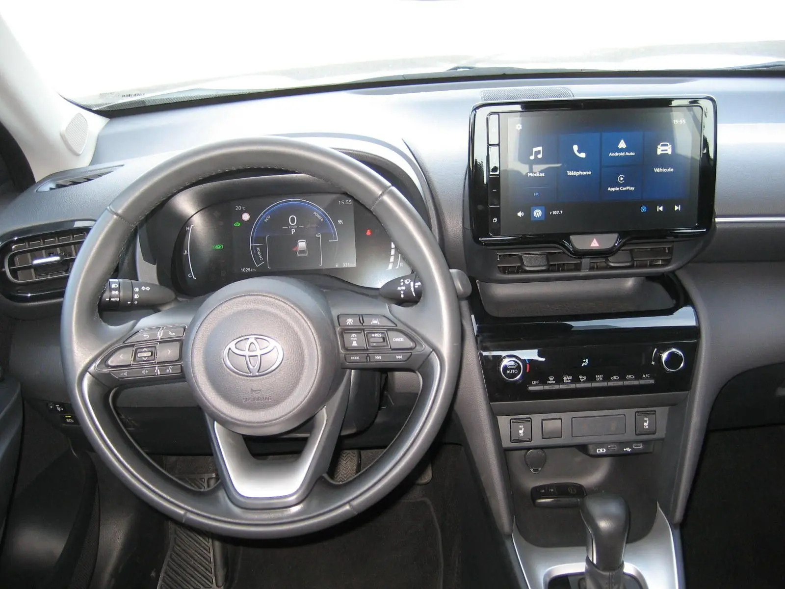 Vue intérieure du tableau de bord et volant noir de la Toyota Yaris Cross 2025, avec écran tactile central allumé.