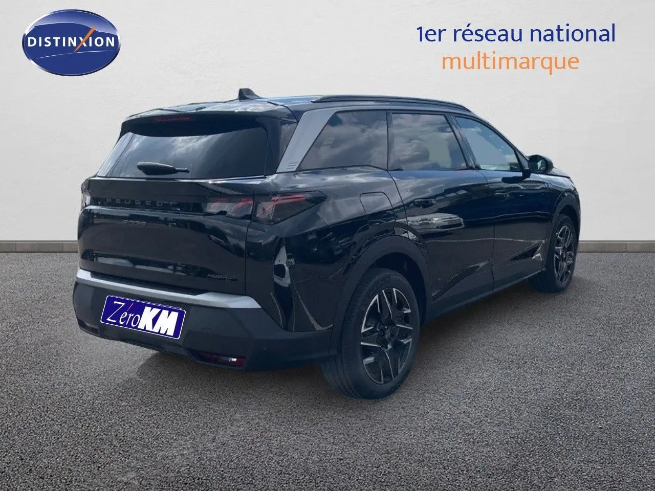 Vue 3/4 arrière droite d'un Peugeot 5008 noir perle métal, SUV hybride 2025 avec jantes noires bicolores.