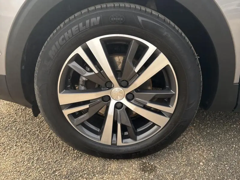 Gros plan sur la jante alliage bi-ton 18 pouces Detroit du Peugeot 3008 gris Artense, avec pneu Michelin visible.