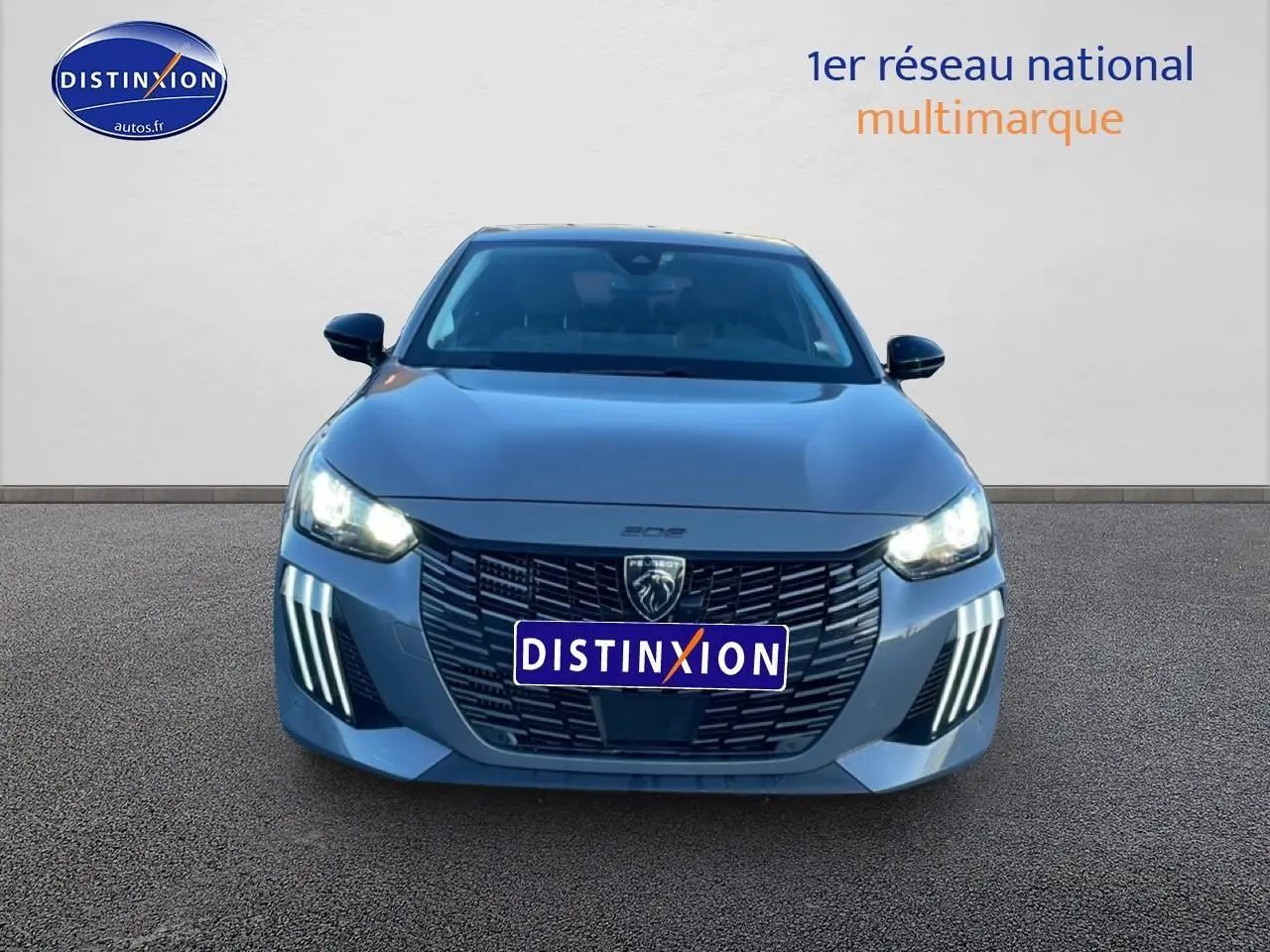 Vue avant frontale d'une Peugeot 208 1.2 100 allure gris sélénite avec phares LED et calandre noire distinctive.