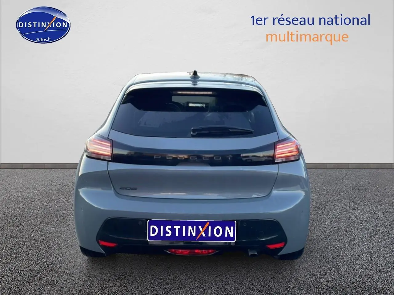 Vue arrière d'une Peugeot 208 1.2 100 allure gris sélénite avec feux arrière LED allumés sur fond neutre.