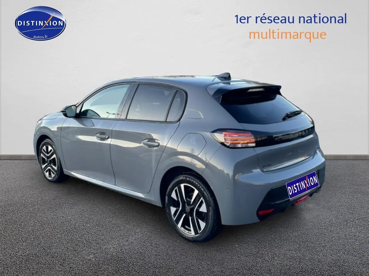 Vue 3/4 arrière droite d'une Peugeot 208 1.2 100 Allure gris Sélénite avec jantes alu et vitres teintées.