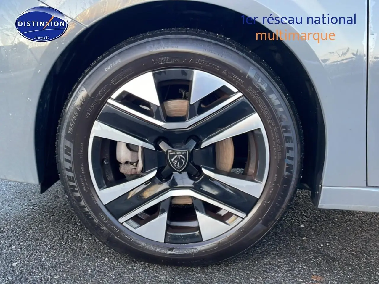 Gros plan sur la roue avant gauche de la Peugeot 208 gris sélénite avec jante alliage bicolore et pneu Michelin.