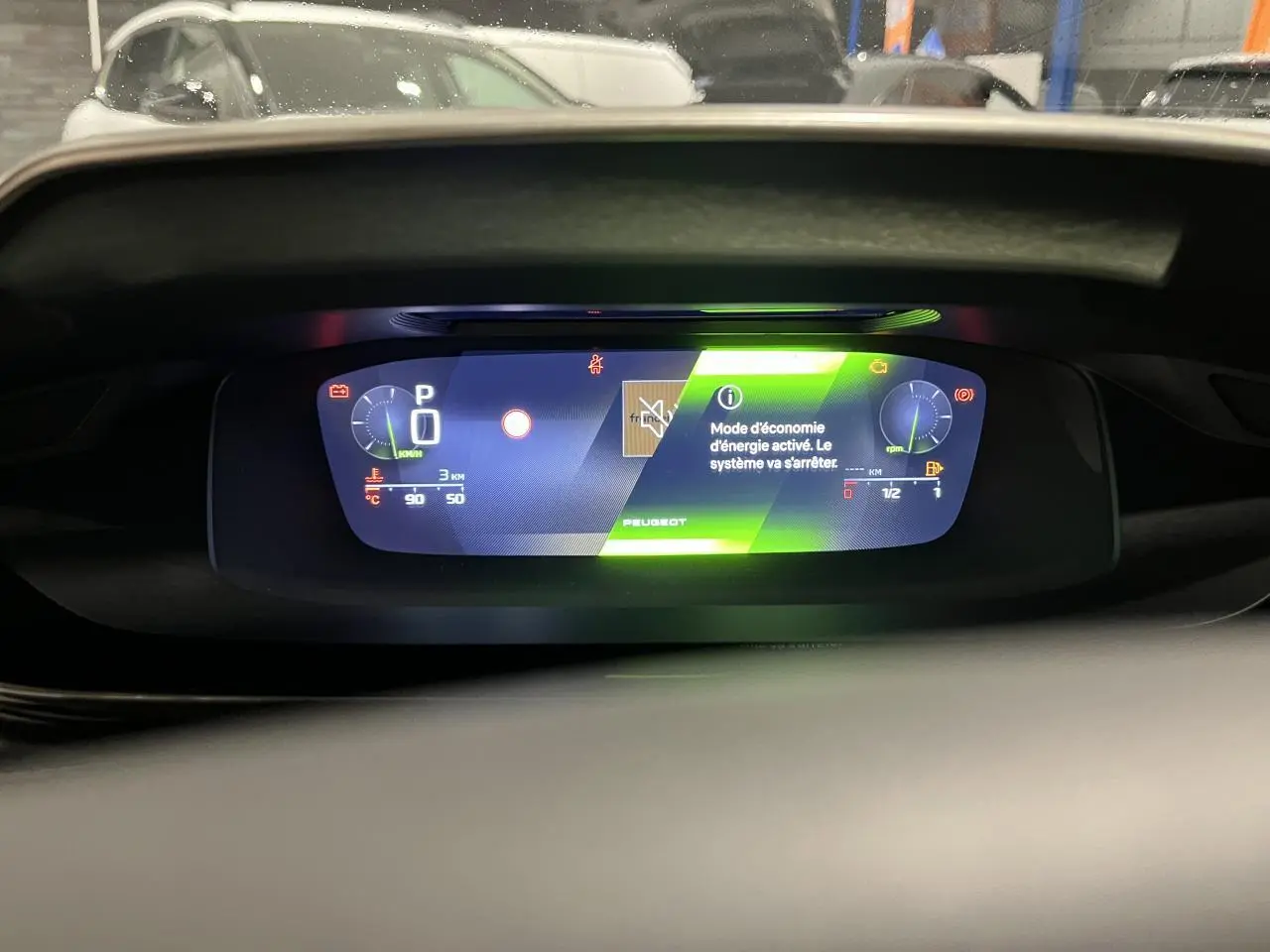 Combiné numérique 10 pouces de la Peugeot 308 GT 2024 affichant le mode économie d'énergie en vert.