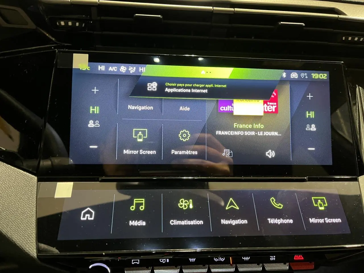 Gros plan sur l’écran tactile central de la Peugeot 308 GT 2024 gris Artense, affichant les menus multimédia et navigation.