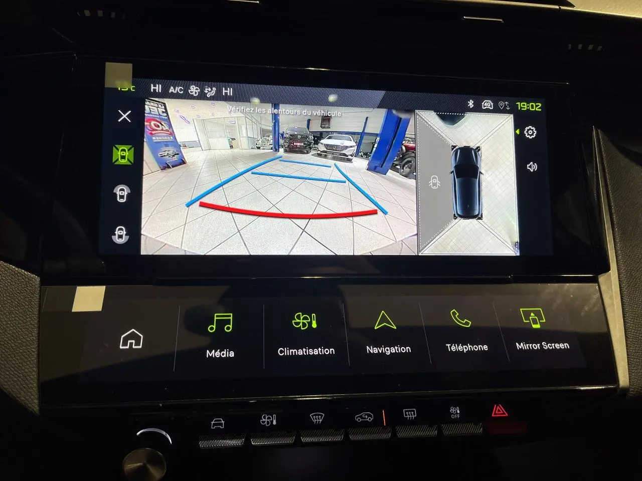 Écran multimédia montrant la caméra de recul et vue 360° d’une Peugeot 308 gris Artense en intérieur.