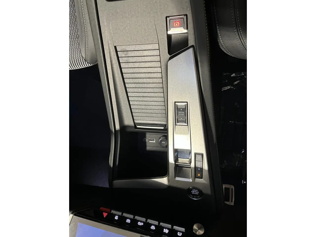 Vue plongeante sur la console centrale de la Peugeot 308 GT 2024 gris Artense avec commandes Drive Mode et frein électrique.